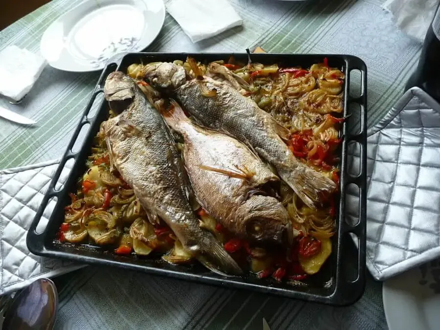 Baked red porgy and seabass on a bed of patatoes and vegetables